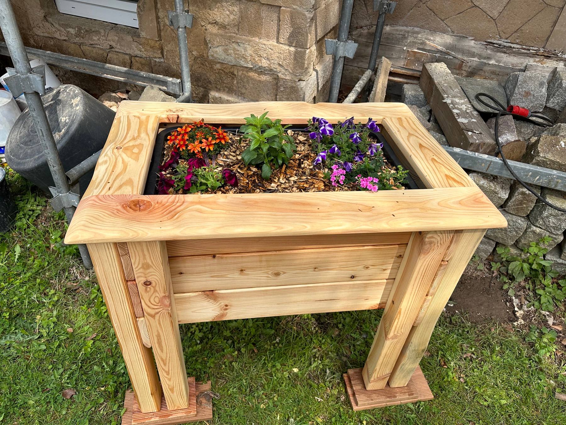 Handgefertigtes Hochbeet aus Holz mit Bepflanzung